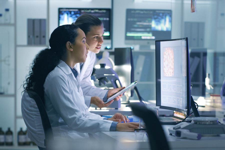 Photo of two scientist looking at a computer screen in a laboratory